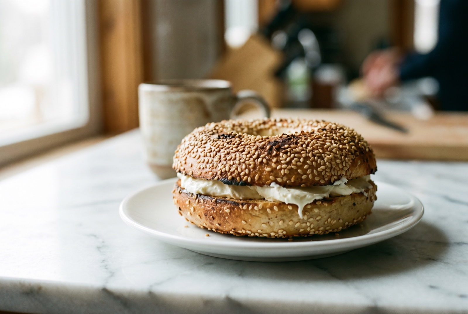 A Montreal-style bagel with cream cheese, editorial food photography