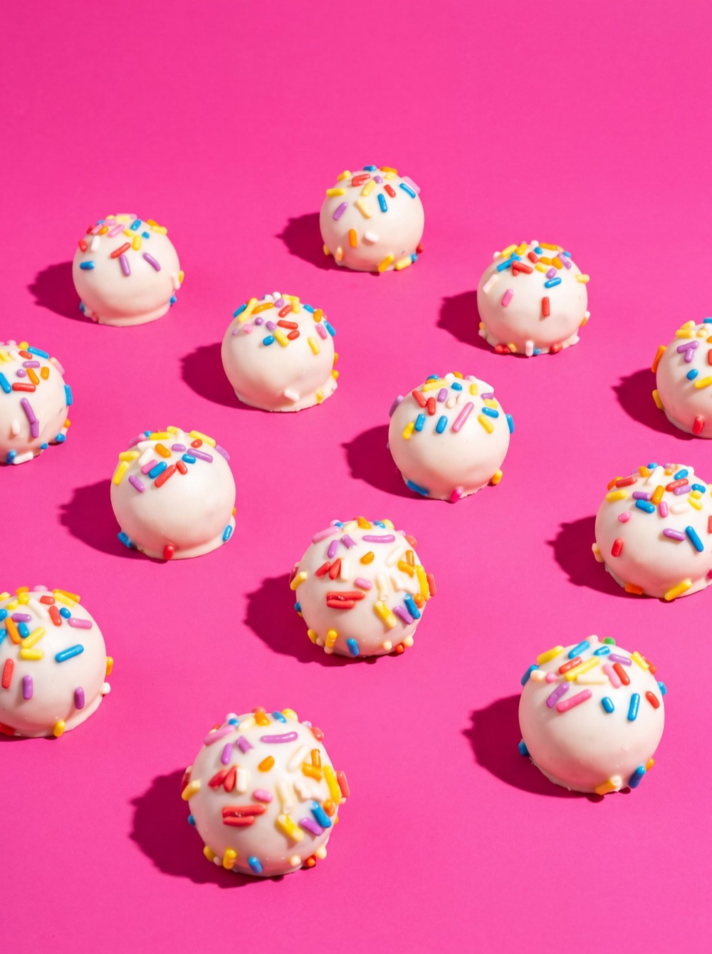Birnn Chocolates Birthday Cake truffles scattered on hot pink