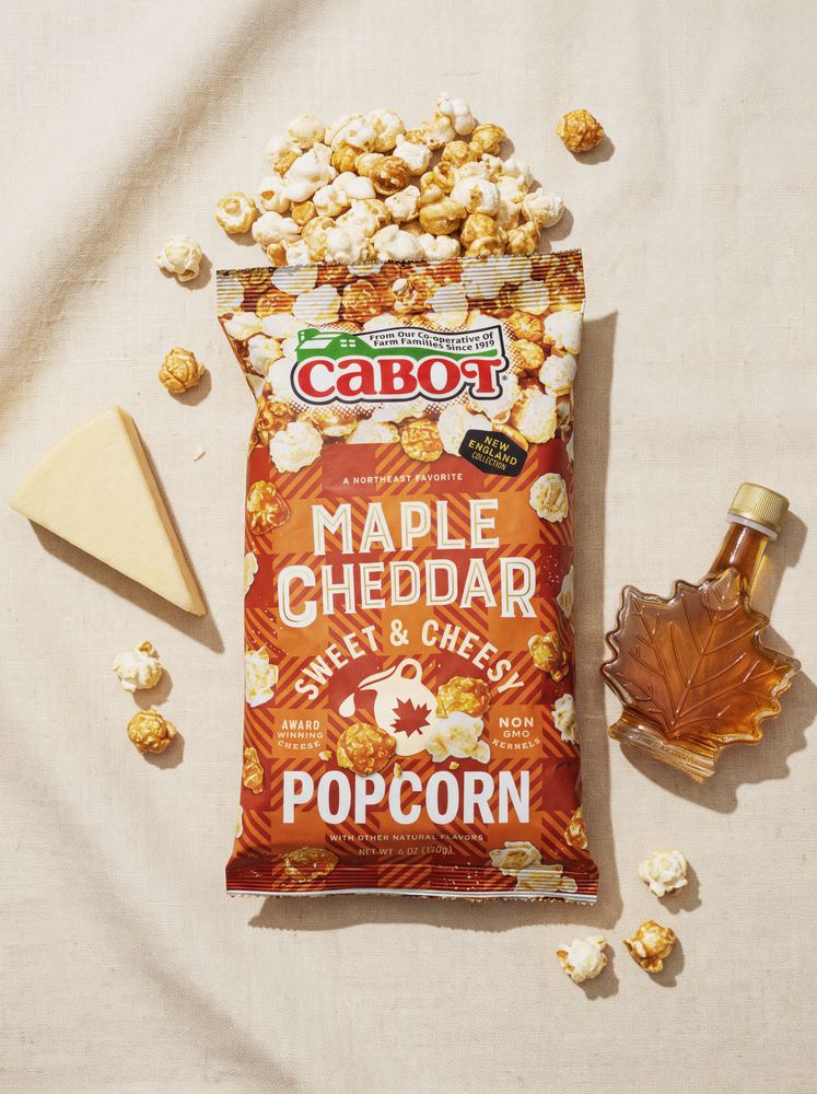 Cabot Maple Cheddar Popcorn flatlay with cheese wedge and maple syrup